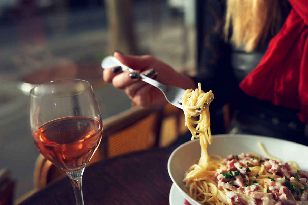 woman-eating-pasta-and-wine-in-nomad-district-italian-market