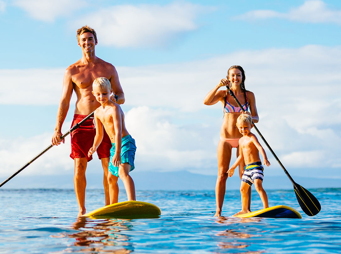 Family of four on standup paddleboards on ocean