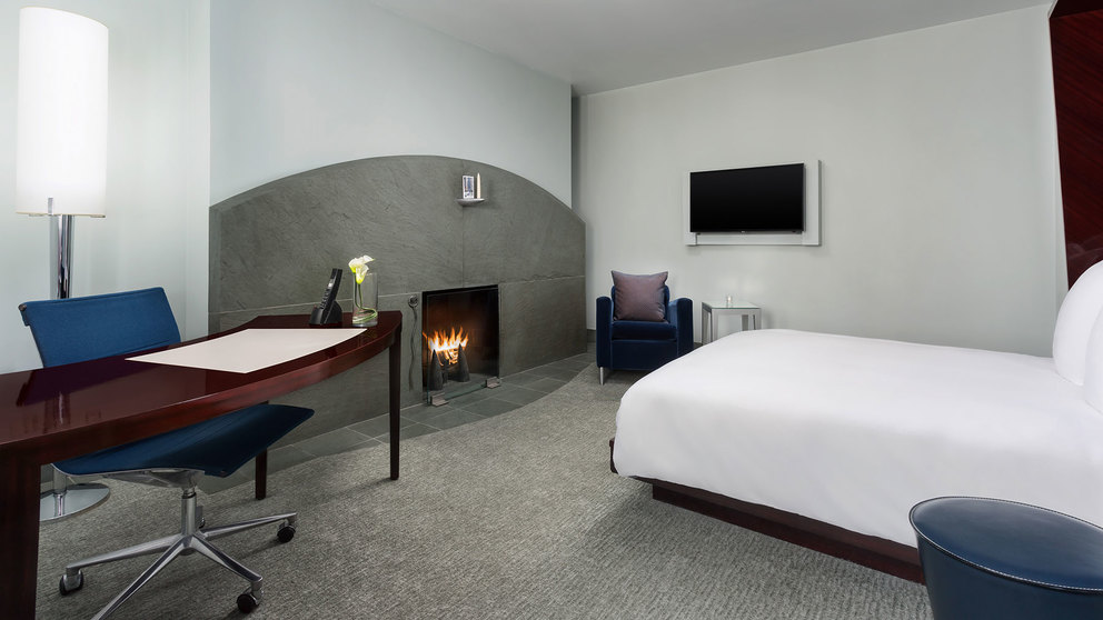 Deluxe Guestroom with Fireplace, desk, chair, TV and bed