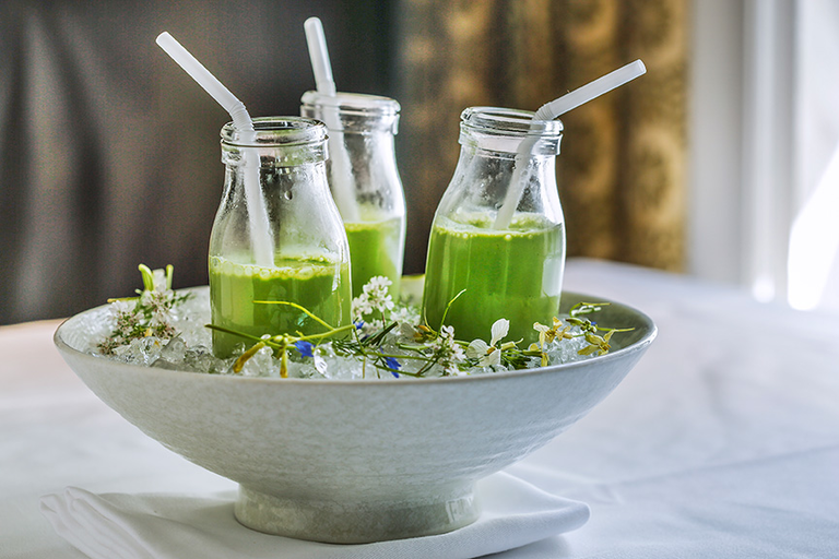 Campton Place Restaurant, three green drink bottles placed inside a bowl filled with ice.