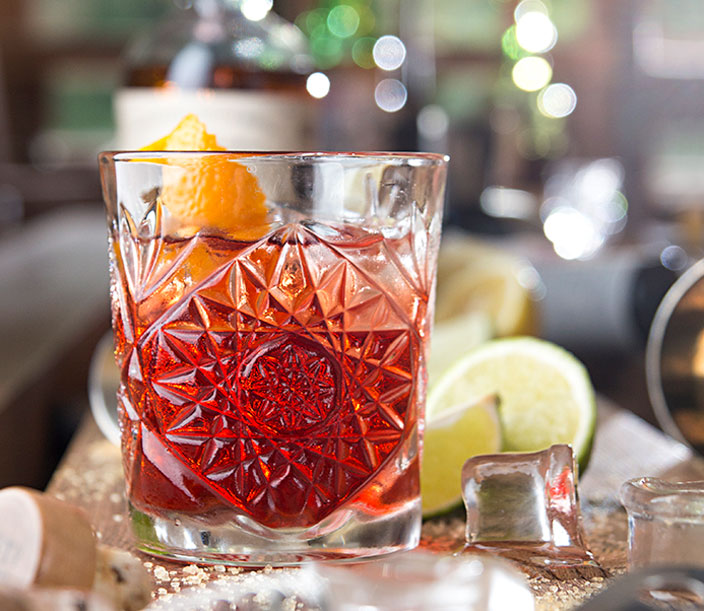 red cocktail with orange slice