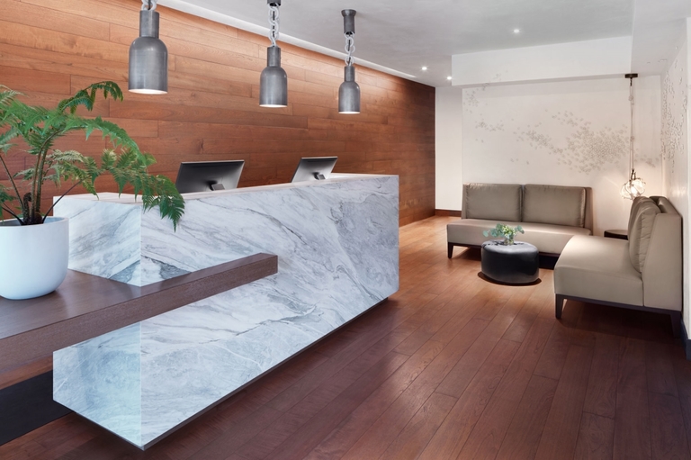 Reception area with marble desk and wood paneling